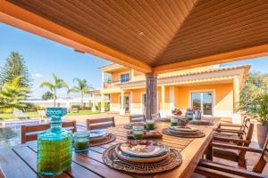 une table en bois avec des assiettes de nourriture sur une terrasse dans l'établissement VILLA Simao, à Guia