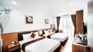 Cette chambre comprend deux lits et une télévision. dans l'établissement Lam Anh Hotel Dương Nội Hà Đông, à Hanoï