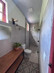 a small bathroom with a toilet and a shower at Pousada Canto Verde in Serra do Cipo