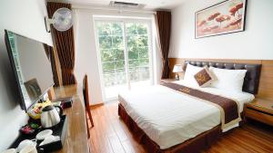 sypialnia z łóżkiem i dużym oknem w obiekcie Lam Anh Hotel Dương Nội Hà Đông w mieście Hanoi