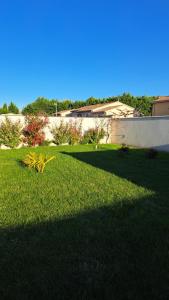 um quintal com relva verde e um edifício em STUDIO tout équipé ISLE SUR LA SORGUE em LʼIsle-sur-la-Sorgue