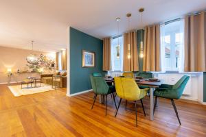 a dining room with a table and green chairs at LIT LIVING Weinheim Altstadt - Boutique Apartments - Parking in Weinheim