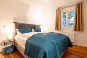 a bedroom with a bed with a blue blanket on it at LIT LIVING Weinheim Altstadt - Boutique Apartments in Weinheim