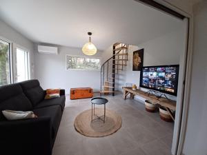 a living room with a couch and a flat screen tv at Chez Emoun et Lina in Caussade