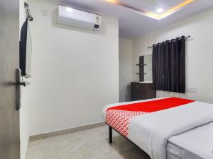 - une chambre avec un lit et une couverture rouge dans l'établissement Red Stone Hotels, à Hyderabad