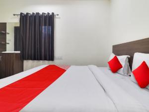 - une chambre avec un grand lit et des oreillers rouges dans l'établissement Red Stone Hotels, à Hyderabad