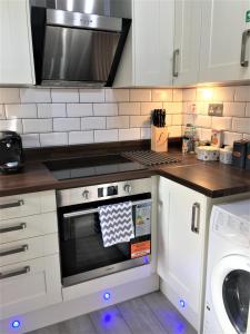 uma cozinha com um fogão e um micro-ondas em Newly Refurb Period 1-Bed Apartment with Roof Terrace, 47 sqm-500 sqft, in Putney near River Thames em Londres