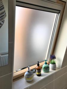 a bathroom mirror with three bottles sitting on a shelf at Newly Refurb Period 1-Bed Apartment with Roof Terrace, 47 sqm-500 sqft, in Putney near River Thames in London +12 photos