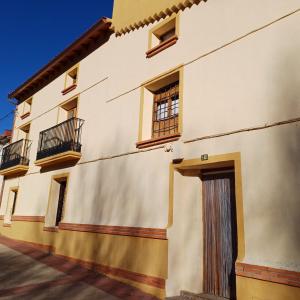 - un bâtiment blanc avec des fenêtres et une porte dans l'établissement El enebro, à Villaverde de Guadalimar