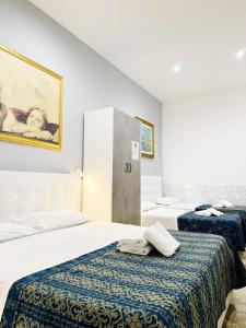- une chambre d'hôtel avec 2 lits et des serviettes dans l'établissement Tawhid Accomodation, à Rome