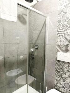 La salle de bains est pourvue d'une douche avec une porte en verre. dans l'établissement Tawhid Accomodation, à Rome