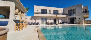 een villa met een zwembad naast een gebouw bij Lalla Essaouira, Villa Najma avec piscine pour 10 personnes in Essaouira