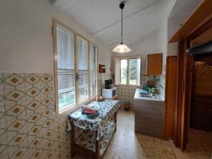 LubrianoにあるCASA VACANZE L'OLIVOの部屋の中央にテーブル付きのキッチン