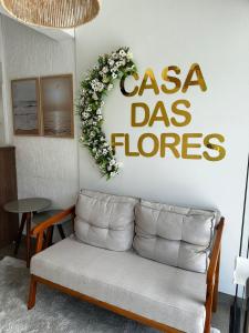 a living room with a couch and a sign that reads casa dos flowers at Casa das Flores in Florianópolis