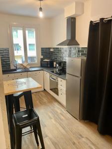 uma cozinha com um frigorífico de aço inoxidável e uma mesa em Appartement centre-ville em Bastia