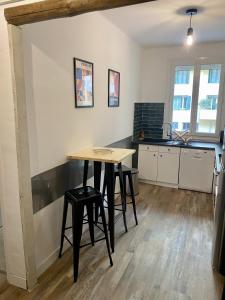 a kitchen with a table and two stools at Appartement centre-ville in Bastia