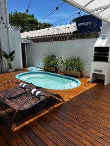 a swimming pool on a wooden deck with a patio at Casa das Flores in Florianópolis