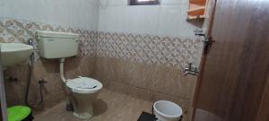 y baño con aseo y lavamanos. en Koonamparayil Home Stay Munnar Anaviratty-Family Only, en Anaviratty