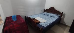 AnavirattyにあるKoonamparayil Home Stay Munnar Anaviratty-Family Onlyの小さなベッドルーム(ベッド1台、テーブル付)