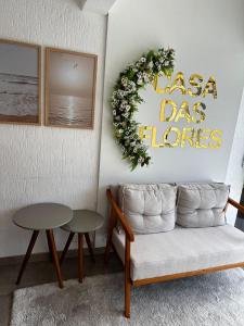a living room with a couch and a wreath on the wall at Casa das Flores in Florianópolis