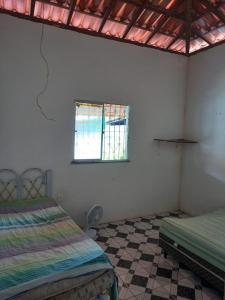 um quarto com duas camas e uma janela em Casa em berlinque, vera cruz. em Vera Cruz de Itaparica
