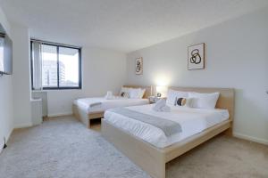 a white bedroom with two beds and a window at Stay with Style in this Condo at Crystal City in Arlington