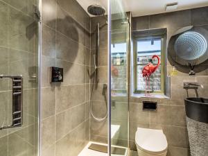a bathroom with a shower and a toilet and a window at 3 bed in Stow-on-the-Wold 49965 in Lower Swell