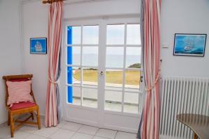um quarto com uma porta e vista para o oceano em Aroura Homes 4BR Beachfront Villa em Spetses