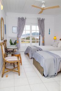 um quarto com uma cama, uma mesa e cadeiras em Aroura Homes 4BR Beachfront Villa em Spetses