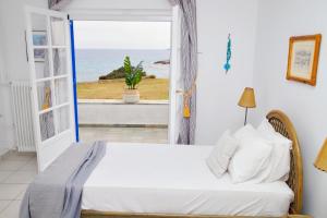 um quarto com uma cama e vista para o oceano em Aroura Homes 4BR Beachfront Villa em Spetses