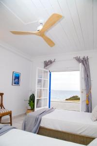 um quarto com 2 camas e uma ventoinha de tecto em Aroura Homes 4BR Beachfront Villa em Spetses