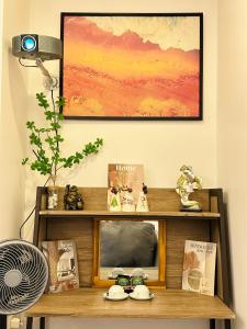 un estante con libros y una foto en la pared en LaLaHome Bắc Ninh en Bắc Ninh