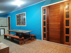 una sala da pranzo con pareti blu e una porta di legno di Casa Pé na Arreia a Arroio do Silva