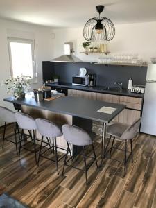 een keuken met een zwart aanrecht en een tafel en stoelen bij Villa SEVEN in Vir