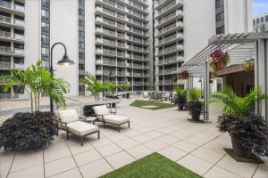 a patio with chairs and tables and tall buildings at Stay with Style in this Condo at Crystal City in Arlington