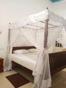 a bed with a canopy in a room at Villa Wasana - Galle in Galle