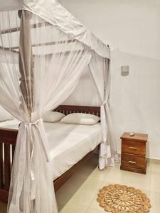 a bedroom with a bed with a canopy and a rug at Villa Wasana - Galle in Galle