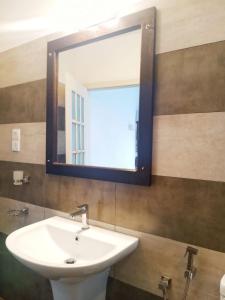a bathroom with a white sink and a mirror at Villa Wasana - Galle in Galle
