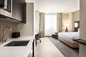 a hotel room with a bed and a kitchen at Residence Inn by Marriott New York JFK Airport in Queens