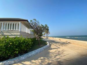 una playa con una casa, una acera y el océano en Baan Talay Samran B4/12D, en Ban Khlong Khot