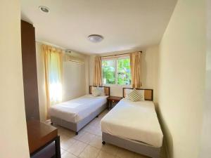 1 dormitorio con 2 camas y ventana en Baan Talay Samran B4/12D, en Ban Khlong Khot