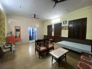 ein Wohnzimmer mit einem Sofa, einem Tisch und Stühlen in der Unterkunft Krishna Aangan in Vrindāvan