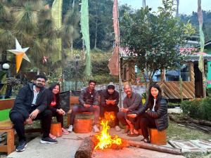 a group of people sitting around a fire at Wake In Himalayas in Pelling