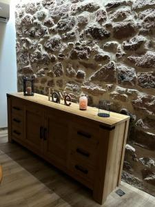 eine Holztheke mit einem Waschbecken vor einer Steinmauer in der Unterkunft Gîte Belle Vue in Thannenkirch