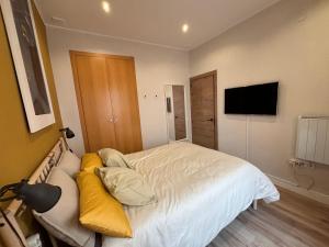 PRECIOUS AND ORIGINAL APARTMENT CENTER في كاديز: غرفة نوم عليها سرير ومخدات صفراء