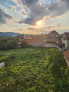 a view of a field with the sunset in the background at Dream House Splai Sebeș in Caransebeş