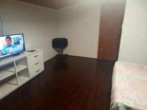 - une chambre avec un lit et une télévision sur une commode dans l'établissement Casa de campo alquiler temporario, à Mar del Plata