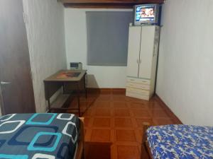 Cette chambre comprend un bureau, un lit et une table. dans l'établissement Casa de campo alquiler temporario, à Mar del Plata