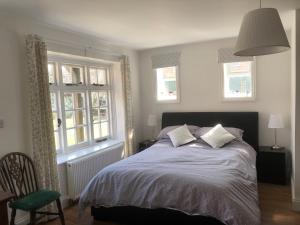 een slaapkamer met een bed en 2 ramen bij The Star in Lydd