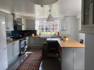 a kitchen with white cabinets and a wooden counter top at The Star in Lydd